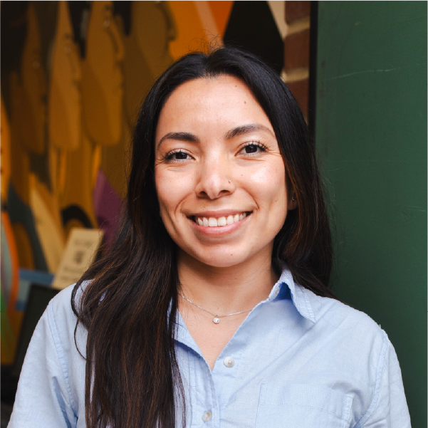 portrait of latinx woman smiling in front of a mural